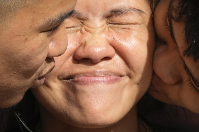 Mary Jane Veloso, center, a Filipino woman who spent almost 15 years in an Indonesian prison for drug trafficking and was nearly executed by firing squad in 2015, is kissed by her sons after being reunited at the Correctional Institution for Women in Mandaluyong, Philippines Wednesday, December 18, 2024. (Photo by Aaron Favila/AP Photo)