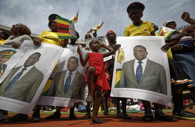 A young girl marches in position as she mimics the military parade, accompanied by supporters holding posters of President Emmerson Mnangagwa, at his inauguration ceremony in the capital Harare, Zimbabwe Friday, November 24, 2017. Mnangagwa was sworn in as Zimbabwe's president after Robert Mugabe resigned on Tuesday, ending his 37-year rule. (Photo by Ben Curtis)/AP Photo