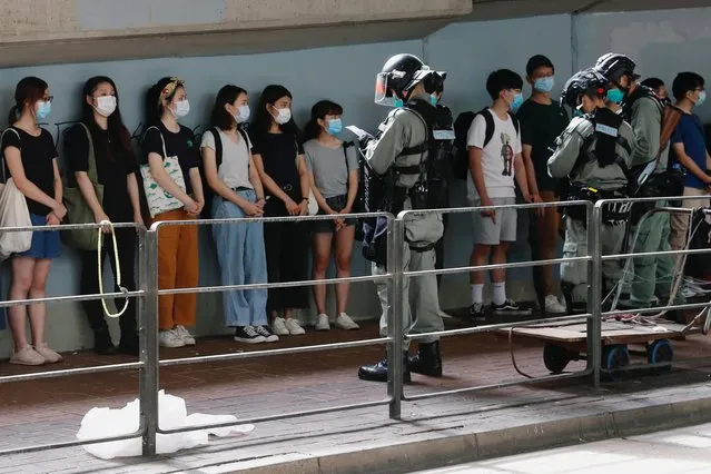 Riot police stop and search people during a march at the anniversary of Hong Kong's handover to China from Britain in Hong Kong, China on July 1, 2020. (Photo by Tyrone Siu/Reuters)