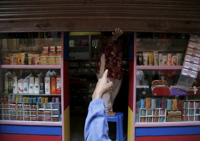 An opposition supporter protesting against the proposed constitution forces a shopkeeper to close a shop during a nationwide strike, called by the opposition parties in Kathmandu, Nepal September 20, 2015. (Photo by Navesh Chitrakar/Reuters)