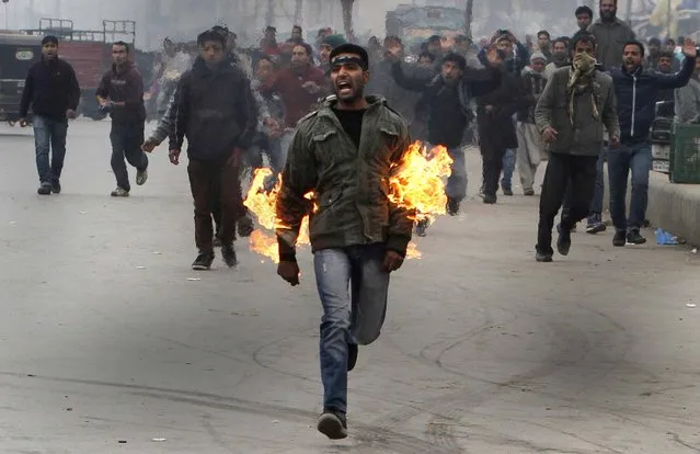 A Kashmiri Shiite mourner runs after he set himself on fire during a Muharram procession in Srinagar, India, November 23, 2012. The Kashmiri man was protesting a police ban on religious processions marking the Muslim month of Muharram in Indian-controlled Kashmir's main city. Police said that clashes erupted when troops tried to stop groups of Shiite Muslims from gathering. (Photo by Associated Press)