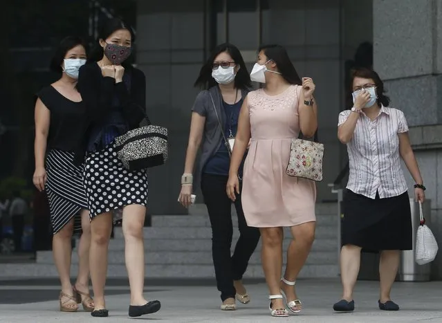 Office workers wearing masks walk during lunch hour at the central business district in Singapore September 29, 2015. (Photo by Edgar Su/Reuters)