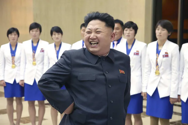 North Korean leader Kim Jong Un smiles as he meets athletes who won gold medals at the 17th Asian Games and recent world championships alongside their coaches in this undated photo released by North Korea's Korean Central News Agency (KCNA) in Pyongyang October 19, 2014. (Photo by Reuters/KCNA)