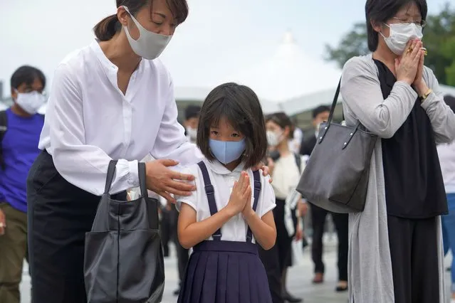 A young girl is accompanied by her mother as she prays in front of a cenotaph at Peace Memorial Park in Hiroshima, western Japan, early 06 August 2020. On 06 August 2020, Japan marks the 75th anniversary of the bombing of Hiroshima. In 1945 the United States dropped two nuclear bombs over the cities of Hiroshima and Nagasaki on 06 and 09 August respectively, killing more than 200,000 people. This year's annual commemoration events were either canceled or scaled down amid the ongoing coronavirus pandemic. (Photo by Dai Kurokawa/EPA/EFE)