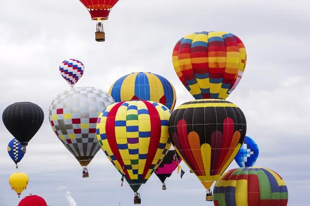Hot air balloons drift through the sky during the 2015 Albuquerque International Balloon Fiesta in Albuquerque, New Mexico, October 4, 2015. (Photo by Lucas Jackson/Reuters)