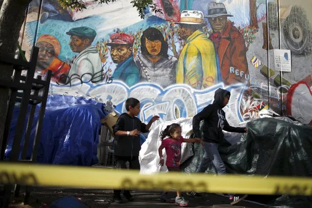People run past a mural on Skid Row in downtown Los Angeles, California, United States, October 1, 2015. Los Angeles officials last week moved to declare the rising problem of homelessness an "emergency" in the city and proposed spending $100 million to provide permanent housing and shelters to help the city's 26,000 indigent. (Photo by Lucy Nicholson/Reuters)