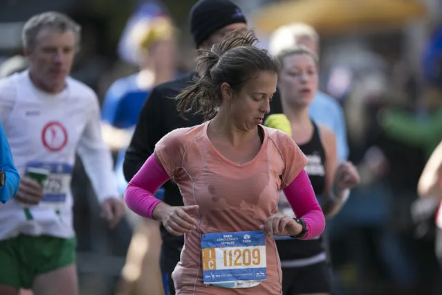 A runner checks her time during the 44th annual New York City Marathon in New York, Sunday, November 2, 2014. (Photo by Gordon Donovan/Yahoo News)