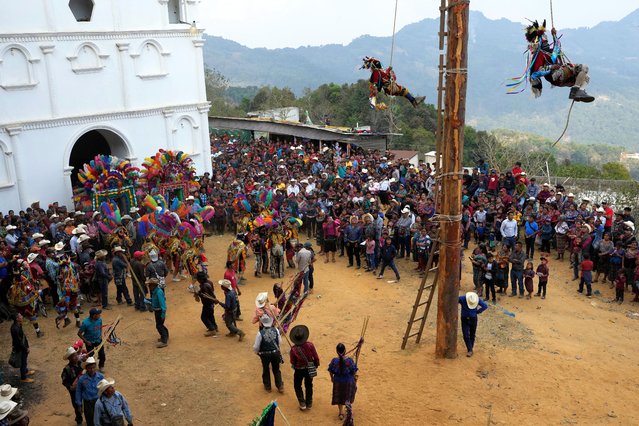 Residents watch the “Danza del Palo Volador”, or “Dance of the Flying Pole”, a ritual in honor of the town's patron saint, Santiago the Apostle, in the Tres Cruces village, Cubulco, Guatemala, Saturday, March 9, 2024. (Photo by Moises Castillo/AP Photo)