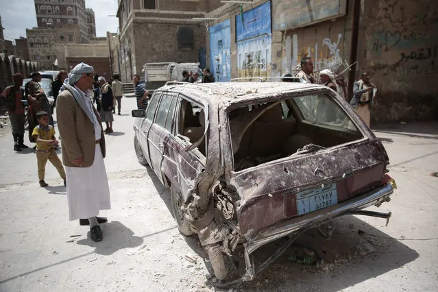 A Yemeni man looks at a damaged car after an airstrike by Saudi-led coalition in Sanaa, Yemen, Tuesday, September 20, 2016. (Photo by Hani Mohammed/AP Photo)