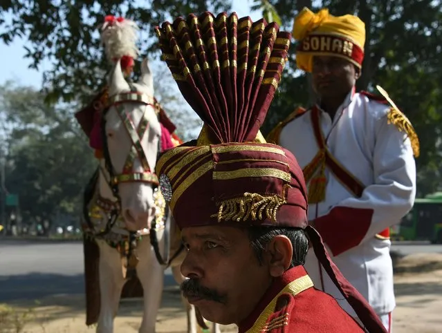 Indian members of a brass band waits on the road prior to performing at a wedding in New Delhi on January 28, 2018. (Photo by Sajjad Hussain/AFP Photo)