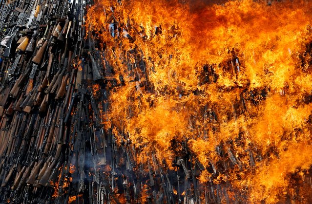 An assortment of 7000 illicit firearms and small weapons, recovered during various security operations, are burnt, at the Regional Centre on Small Arms in the Great Lakes Region, the Horn of Africa and Bordering States' (RECSA) 20th anniversary celebrations, at the National Police Leadership Academy in the Bulbul area of Ngong district near Nairobi, Kenya on June 13, 2025. (Photo by Thomas Mukoya/Reuters)