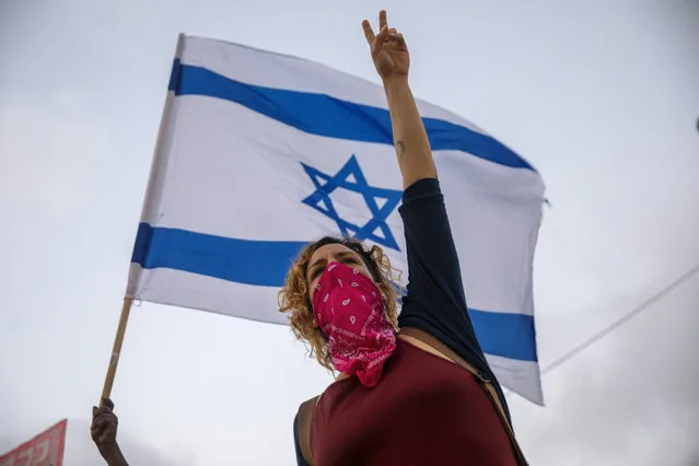 Israeli protesters wave flags and chant slogans during a demonstration against parliament's plans to ban them from protesting during the current nationwide lockdown due to the coronavirus pandemic, in Tel Aviv, Israel, Tuesday, September 29, 2020. The protesters accuse Prime Minister Benjamin Netanyahu of exploiting the coronavirus crisis in order to stop weeks of demonstrations against him. (Photo by Oded Balilty/AP Photo)