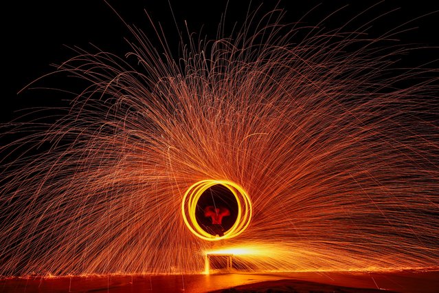 A dancer plays with fire on Chao Lao Beach, in Chanthaburi province, Thailand, on June 7, 2025. (Photo by Chalinee Thirasupa/Reuters)