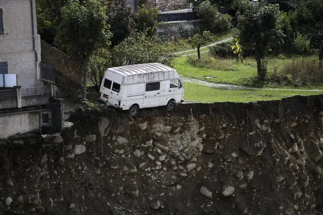 A small van is about to fall in a ravine after floods in Saint-Martin-Vesubie, southwestern France, Tuesday, October 6, 2020. More than a dozen deaths have been reported since the storm pounded France's Alpes-Maritimes region and Italy's northwestern regions of Liguria and Piedmont starting Friday – four on the French side, eight on the Italian side. (Photo by Daniel Cole/AP Photo)