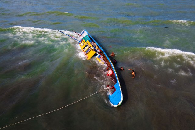 An aerial view shows a fishing boat which capsized due to weather conditions by the coast in Banda Aceh on June 23, 2025. (Photo by Chaideer Mahyuddin/AFP Photo)