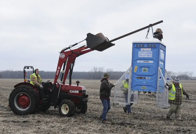 Members of the Michiana Rocketry prep a 10-foot, 450 pound porta-potty, mounted on rocket motors for launching, Saturday, December 6, 2014, from a field in Three Oaks, Mich. (Photo by Don Campbell/AP Photo/The Herald-Palladium)