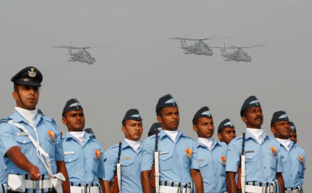 Indian Air Force soldiers march as Mil Mi-35 gunship helicopters fly during the Indian Air Force Day celebrations at the Hindon Air Force Station on the outskirts of New Delhi, India, October 8, 2016. (Photo by Adnan Abidi/Reuters)