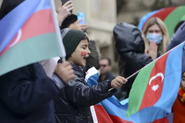 Azerbaijanis with the national flags celebrate after the country's President claimed Azerbaijani forces have taken Shushi, a key city in the Nagorno-Karabakh region that has been under the control of ethnic Armenians for decades in Baku, Azerbaijan, Sunday, November 8, 2020. (Photo by AP Photo/Stringer)