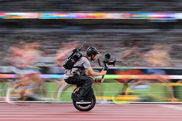 A cameraman on a unicycle films athletes in action as they compete in the men's 10000m final during the World Athletics Championships in Tokyo on September 14, 2025. (Photo by Kirill Kudryavtsev/AFP Photo)