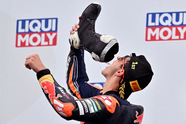 Red Bull KTM Tech3 team's Spanish Moto3 rider Jose Antonio Rueda drinks champagne from his boot as he celebrates winning the Moto3 race at the MotoGP Australian Grand Prix on Philip Island on October 19, 2025. (Photo by Paul Crock/AFP Photo)