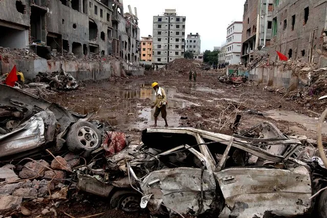 A man walks at the site of the collapsed garment-factory building in Savar, Bangladesh, on May 13, 2013. Nearly three weeks after the building collapsed, the search for the dead ended Monday at the site of the worst disaster in the history of the global garment industry. The death toll: 1,127. (Photo by A. M. Ahad/Associated Press)