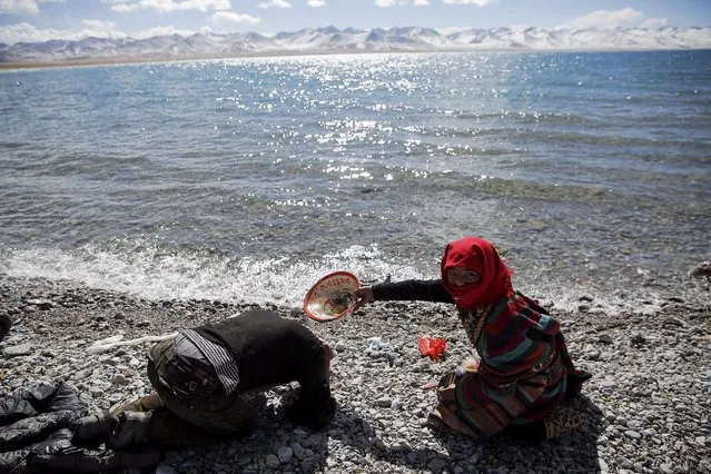 A Tibetan woman helps a man to wash his hair with water from Namtso lake in the Tibet Autonomous Region, China November 18, 2015. (Photo by Damir Sagolj/Reuters)