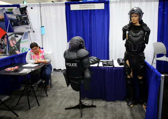 A sales person sits at her booth selling police riot gear at the International Association of Chiefs of Police conference in San Diego, California, U.S. October 17, 2016. (Photo by Mike Blake/Reuters)