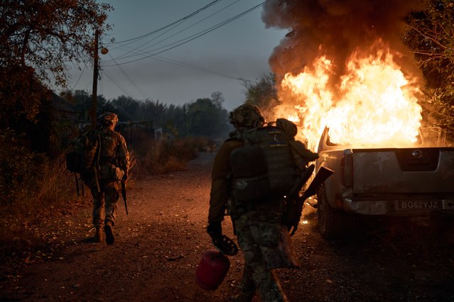 Ukrainian soldiers inspect a vehicle recently struck by a Russian FPV kamikaze drone that ambushed them near the frontline on October 16, 2025 in Kostiantynivka, Ukraine. The frontline city of Kostiantynivka lies in ruins after months of relentless Russian assaults, with destroyed buildings, empty streets, and traces of both military presence and civilian survival visible throughout the area. (Photo by Kostiantyn Liberov/Libkos/Getty Images)
