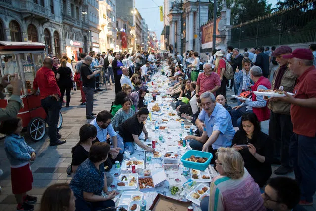 Turkish people break their fast on the first day of Ramadan on Istiklal Street, near Taksim Square in Istanbul, Turkey, 16 May 2018. Muslims around the world celebrate the holy month of Ramadan by praying during the night time and abstaining from eating, drinking, and sexual acts daily between sunrise and sunset. Ramadan is the ninth month in the Islamic calendar and it is believed that the Koran's first verse was revealed during its last 10 nights. (Photo by Tolga Bozoglu/EPA/EFE)