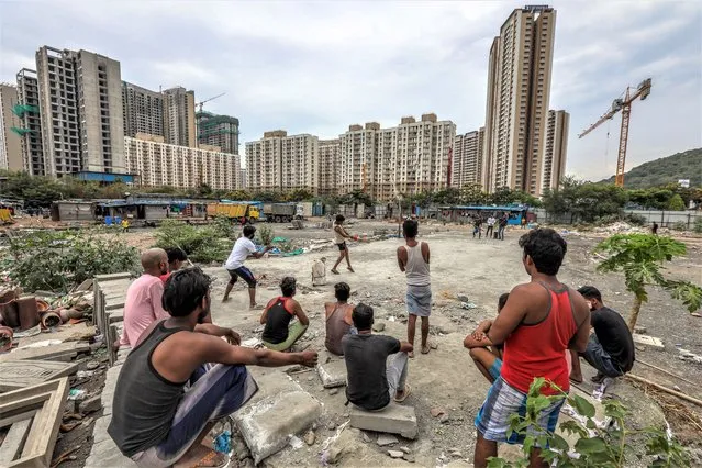 Indian laborers play cricket near an under-construction site on International Workers' Day, in Mira Road, on the outskirts of Mumbai, India, 01 May 2023. Labour Day, or May Day, is observed all over the world on the first day of May to celebrate the economic and social achievements of workers and the fight for laborer’s rights. (Photo by Divyakant Solanki/EPA)