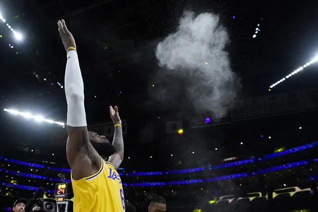 Los Angeles Lakers forward LeBron James tosses powder in the air prior to Game 4 of an NBA basketball Western Conference semifinal against the Golden State Warriors Monday, May 8, 2023, in Los Angeles. (Photo by Marcio Jose Sanchez/AP Photo)