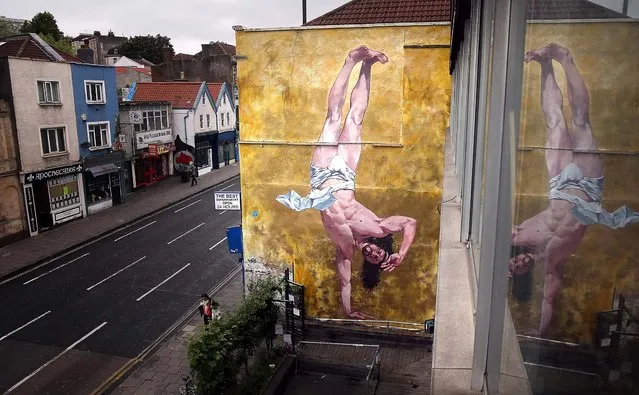 Cosmo Sarson's mural of Jesus breakdancing fills an 8.5 meter wall beside The Canteen in Bristol, England, on June 11, 2013. The mural was inspired by an actual event in the Vatican, where breakdancers performed to an applauding Pope John Paul II in 2004. The new mural “represents everything Bristol should be proud of and will remain on the wall for two years”,  James Pike from the Canteen told  the BBC. “We have a proud history of religious tolerance, incredible cultural diversity and a vibrant creative history”. (Photo by Matt Cardy/Getty Images)