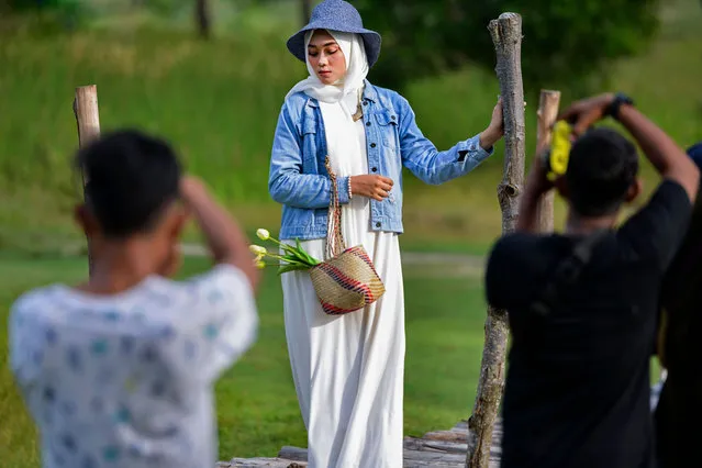 A model poses for photographers during a gathering at Lhoknga Beach, Aceh province on January 31, 2021. (Photo by Chaideer Mahyuddin/AFP Photo)
