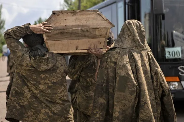 Ukrainian servicemen carry a coffin with the body of a person who is considered to be former U.S. Army soldier Nicholas Maimer, killed in the frontline town of Bakhmut, after prisoners of war (POWs) swap, amid Russia's attack on Ukraine, in Donetsk region, Ukraine on May 25, 2023. (Photo by Yevhenii Zavhorodnii/Reuters)