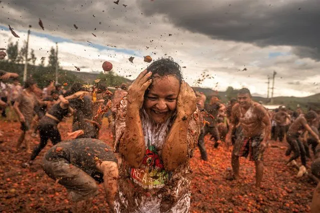 People throw tomatoes during the celebration of the 14th Colombian Tomato Festival on June 11, 2023 in Sutamarchan, Colombia. In this annual festival, locals and tourists throw ripe tomatoes to celebrate the harvest season. (Photo by Diego Cuevas/Getty Images)