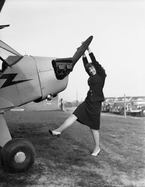 Norma Ellen Kristoff, the first of the girls at the big defense plant to join the flying club poses with a propeller plane in Hobart, Indiana, May 7, 1942. She is employed as a secretary in the company's office. (Photo by AP Photo)