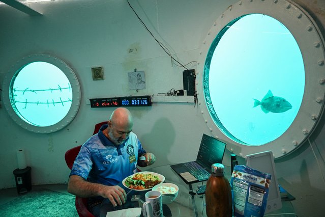 German aerospace engineer Rudiger Koch, 59, takes breakfast inside an underwater room off the coast of Puerto Lindo, Panama, on January 24, 2025. On January 24, Koch is set to break the Guinness world record for living in the ocean at a depth of eleven meters for 121 days. (Photo by Martin Bernetti/AFP Photo)