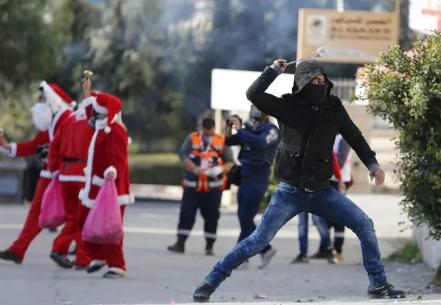 A Palestinian protester uses a sling to hurl stones towards Israeli troops during clashes following an anti-Israel protest in the West Bank city of Bethlehem December 18, 2015. (Photo by Ammar Awad/Reuters)