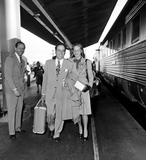 Actor Humphrey Bogart and actress Lauren Bacall are shown at a train station before they board the Santa Fe in Los Angeles, Ca., on May 18, 1945.  The couple will travel to Mansfield, Ohio, where they will get married at a friend's farm.  The person at left is unidentified. (Photo by AP Photo)