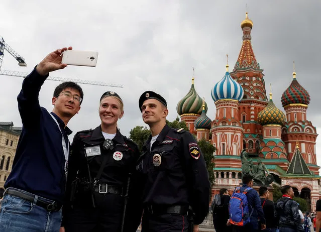 Police officers pose for a picture with tourists at the Red Square in Moscow, Russia July 10, 2018. (Photo by Gleb Garanich/Reuters)
