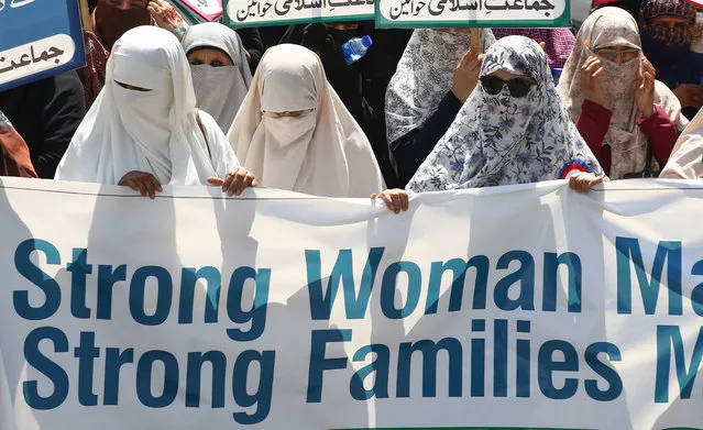 Supporters of Islamic political party Jamat-e-Islami hold placards during a rally to mark International Women's Day in Karachi, Pakistan, 08 March 2021. International Women's Day is globally observed on 08 March to highlight the struggles of women around the globe. It was proclaimed by the United Nations General Assembly as the day for women's rights and world peace in 1977. (Photo by Shahzaib Akber/EPA/EFE)