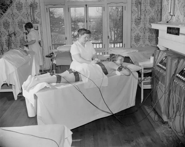 In the latest in fat-reduction fads, the young lady on the table at Marble Hall Women's Health Club at Rye, N.Y., March 17, 1948, is worked over by the spot reducer, which takes car of unwanted bulges and increases circulation of blood through fatty deposits. This eliminates the need for exercise which tends to firm already solid flesh and makes the trainee over-hungry at mealtime. (Photo by Dan Grossi/AP Photo)