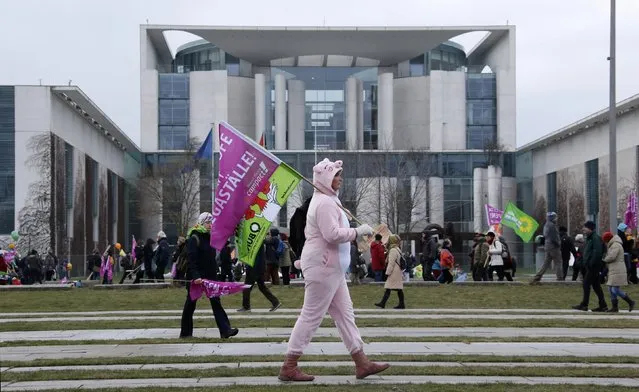 A protester walks with a flag during a demonstration of German farmers and consumer rights activists against mass animal husbandry and genetic engineering outside the Chancellery in Berlin, Germany, January 16, 2016. (Photo by Fabrizio Bensch/Reuters)
