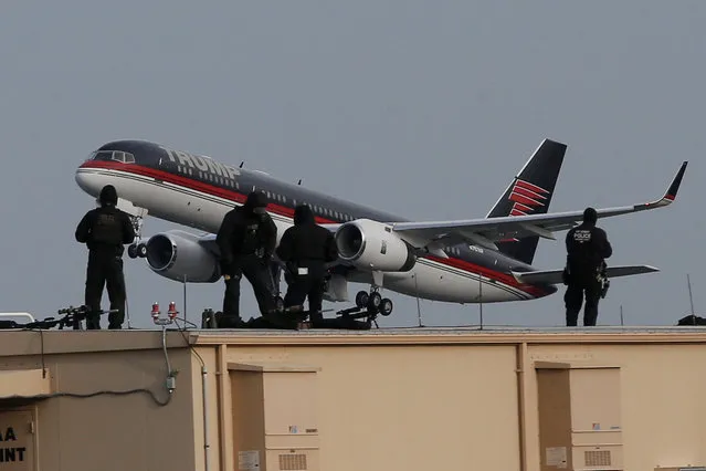 Law enforcement personnel look on from a rooftop while U.S. President-elect Donald Trump's plane takes off as Trump is travelling to Ohio from LaGuardia Airport in New York City, U.S. December 8, 2016. (Photo by Mike Segar/Reuters)