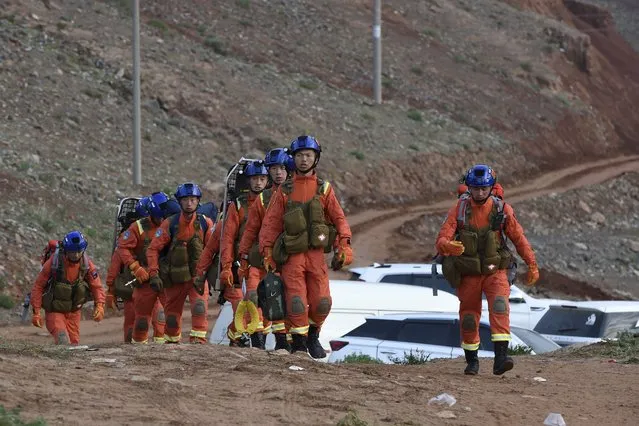 In this photo provided by China's Xinhua News Agency, rescuers walk into the accident site to search for survivors in Jingtai County of Baiyin City, northwest China's Gansu Province, Sunday, May 23, 2021. More than a dozen of people running a mountain marathon have died in northwestern China after hail, freezing rain and gale-force winds hit the high-altitude race, state media reported Sunday. (Photo by Fan Peishen/Xinhua via AP Photo)
