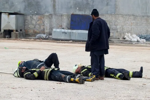 Civil defence members rest after extinguishing a fire that broke out after what activists said were airstrikes carried out by the Russian air force in the town of Sarmada, in Idlib Governorate near the Syrian-Turkish border, January 22, 2016. (Photo by Ammar Abdullah/Reuters)