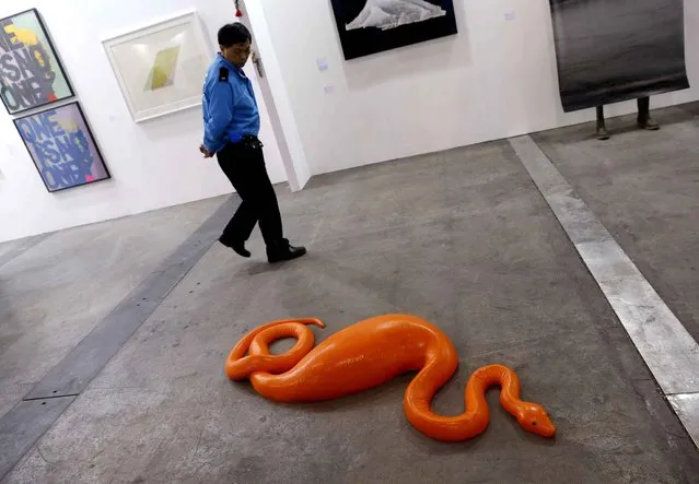 A security guard walks past an artwork “Snake” created by Belgian artist Carsten Holler during the VIP preview of the art fair Art Basel in Hong Kong Friday, March 13, 2015. (Photo by Kin Cheung/AP Photo)