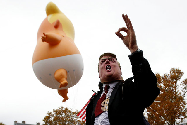 A demonstrator with a mask depicting U.S. President Donald Trump attend a protest against U.S. President Donald Trump at Place de la Republique, as part of the commemoration ceremony for Armistice Day, 100 years after the end of the First World War, in Paris, France, November 11, 2018. (Photo by Stephane Mahe/Reuters)