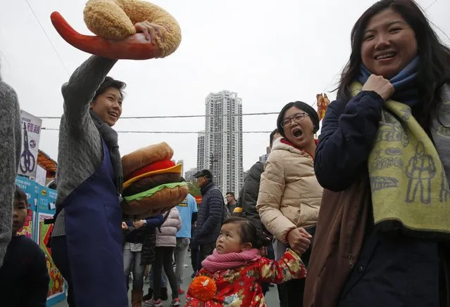 A vendor, left, sells toy Shrimp Tempura and burger for decorations at a annual market in Hong Kong, Wednesday, February 3, 2016. Chinese will celebrate the Lunar New Year on Feb. 8 this year which marks the Year of Monkey on the Chinese zodiac. (Photo by Kin Cheung/AP Photo)