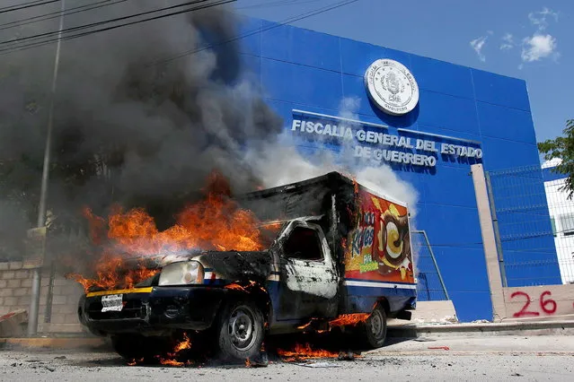 A vehicle burns during a demonstration in front of the State Attorney General's Office to demand justice for the 43 missing students from Ayotzinapa, in Chilpancingo, Guerrero, Mexico, 23 September 2023. Mexican students vandalized the facilities of the State Attorney General's Office (FGE) and set fire to a van, as part of protests they are carrying out days before the ninth anniversary of the disappearance of the 43 students from Ayotzinapa. (Photo by Jose Luis de la Cruz/EPA)